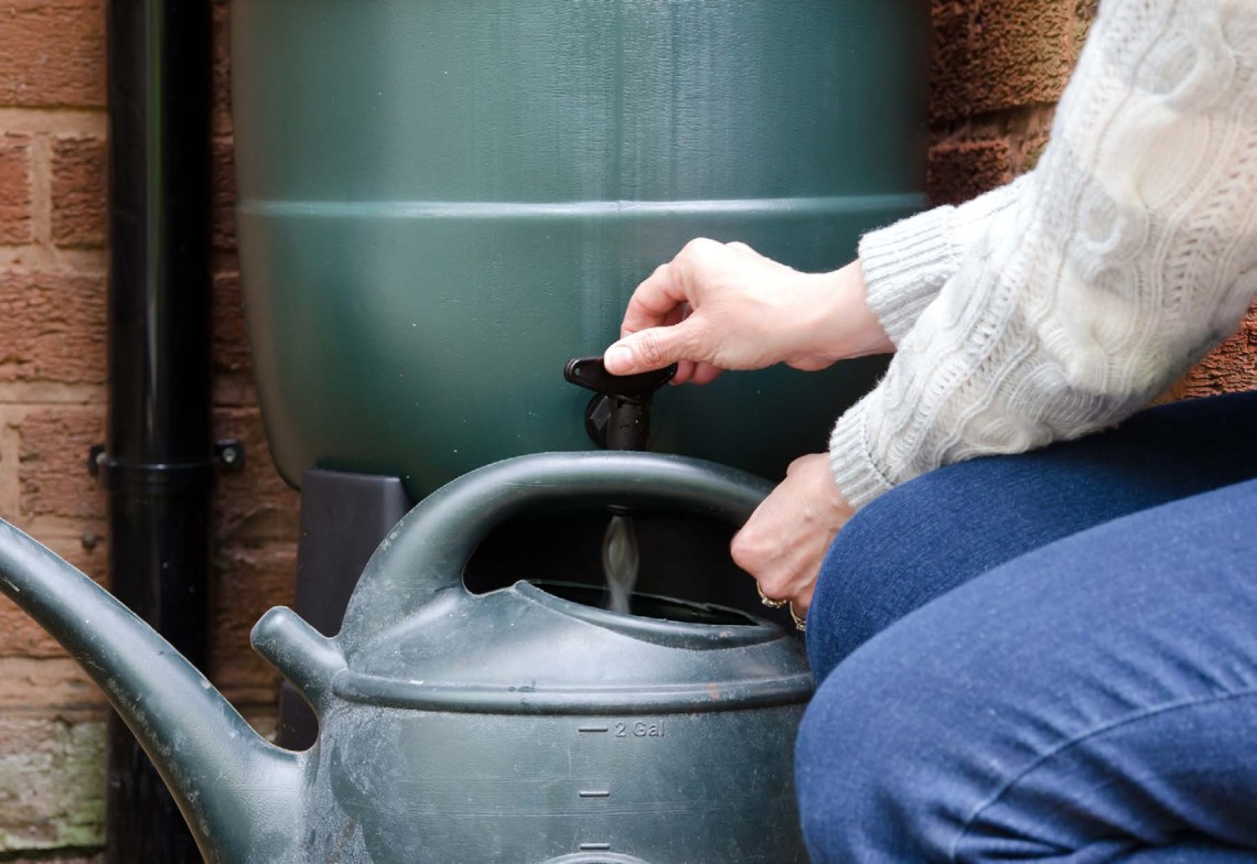 Filling a watering can from a water tank 